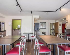 The hotel breakfast area has a hard floor and tables for two to four diners.