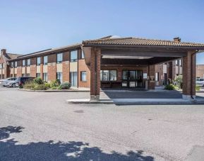 The entrance to Comfort Inn Gatineau is under cover, with nearby greenery and ample parking.