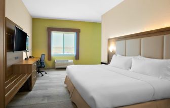 Comfortable king bedroom with TV and business desk at Holiday Inn Express & Suites Ontario.