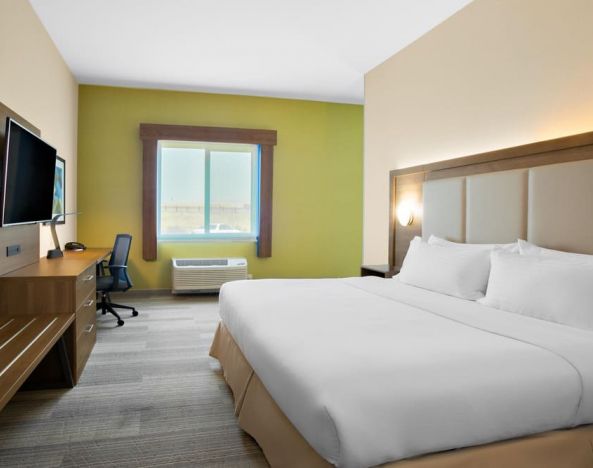 Comfortable king bedroom with TV and business desk at Holiday Inn Express & Suites Ontario.