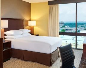 King bed with work desk and natural light at DoubleTree San Antonio Airport.