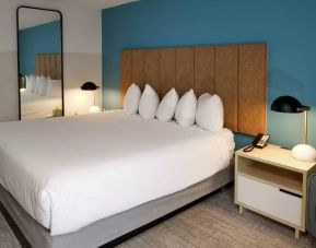 Hotel Thea - Ascend Collection guest room with large double bed and full-length mirror.