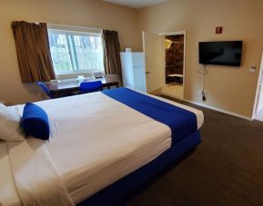 Spacious king bedroom with TV and work station at Colony Inn Universal Studios.