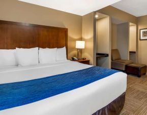Spacious king bedroom with TV and work station at Comfort Inn & Suites Sea-Tac Airport.