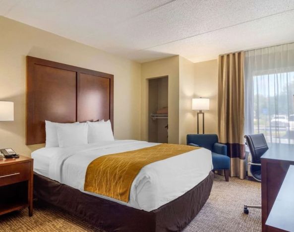 Delux king bed with TV and business desk at Comfort Inn Atlanta Airport.