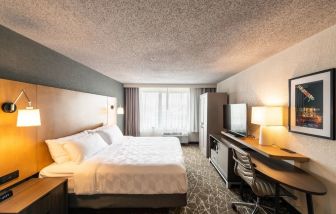 Spacious king bedroom with TV and work station at Holiday Inn Newark International Airport-North.