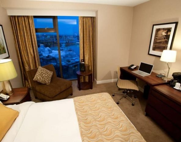 Delux king bed with business desk at Pacific Gateway Hotel Vancouver Airport.