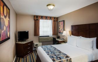 Spacious king bedroom with TV and work station at Ramada by Wyndham Vancouver Downtown.