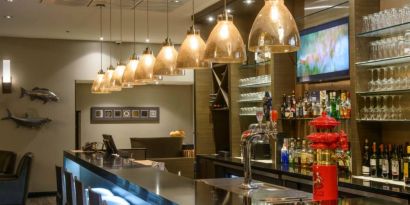 The hotel’s bar has tall stools, art on the wall, and a broad selection of beverages.