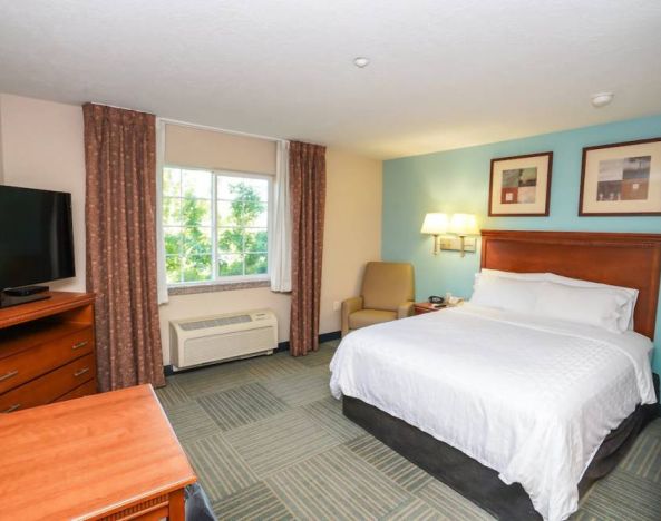Double bed guest room in Candlewood Suites Meridian, with TV and window.