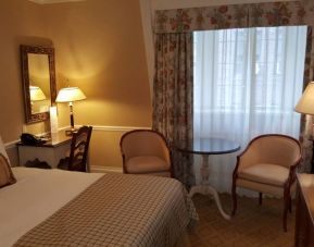 The Wall Street Inn guest room, featuring chairs, coffee table, and window.