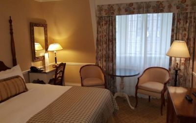The Wall Street Inn guest room, featuring chairs, coffee table, and window.