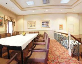 Hotel meeting room, with long table, surrounding chairs, and a large TV on the wall.
