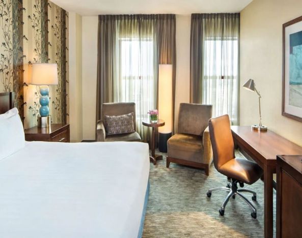 Delux king bed with TV and business desk at Hyatt Regency Buffalo Hotel And Conference Center.