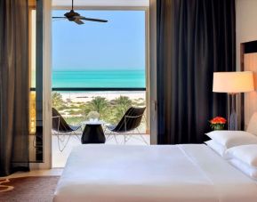 Spacious king bedroom with TV and work station at Park Hyatt Abu Dhabi Hotel & Villas.