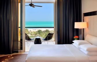 Spacious king bedroom with TV and work station at Park Hyatt Abu Dhabi Hotel & Villas.