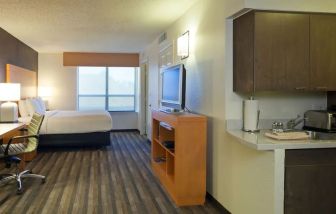 Spacious king bedroom with TV and work space at Hyatt House Houston / Galleria.