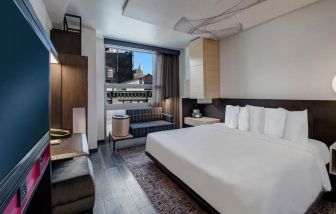 Delux king bed with TV and business desk at Hyatt Herald Square New York.