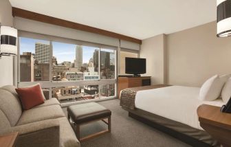 Delux king bed with TV and business desk at Hyatt Place New York Midtown South.