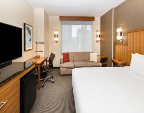 Spacious king bedroom with TV and work space at Hyatt Place New York Midtown South.