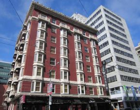 Exterior of the Mosser Hotel, with vertical sign and vibrant red brick hue.