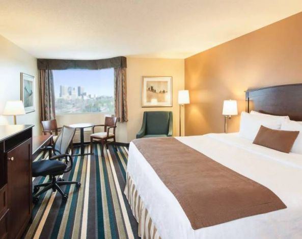 Best Western Plus Winnipeg Airport guest room, including large bed, and desk and chair for working.