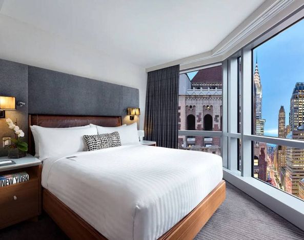 Hotel 48LEX New York guest room with double bed and stunning city view.