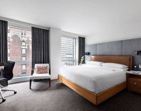 A guest room of the Hotel 48LEX New York, with large double bed, and workspace desk and chair.