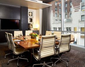 One of the hotel’s meeting rooms, with eight chairs around a long table, and a large TV screen.