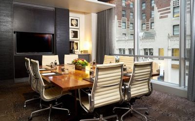 One of the hotel’s meeting rooms, with eight chairs around a long table, and a large TV screen.