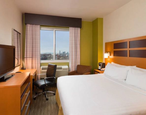 Guest room of the Holiday Inn Express Times Square, with double bed, window, TV, and desk.