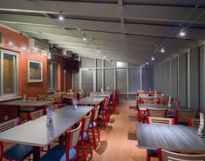 The hotel’s breakfast area, which has a hard floor and tables for four or more diners.