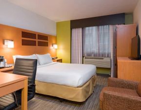 One of Holiday Inn Express Times Square’s guest rooms, with comfy chair, space for working, and window, plus double bed.