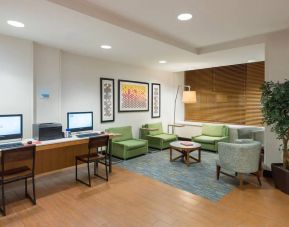 The Holiday Inn Express Times Square’s lounge, with comfy chairs, coffee table, and two workstations.