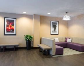 Hampton Inn Times Square South’s lobby lounge, with art on the walls and comfortable sofa seating.