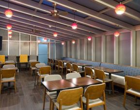 The hotel’s breakfast area, with hard floor and tables for two or four diners.