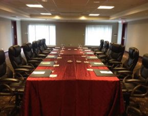 Meeting room with a dozen leather chairs arranged around a long table.