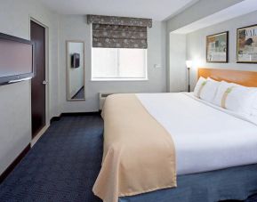 Double bed guest room in the Holiday Inn Express Wall Street, with window, TV, and mirror.