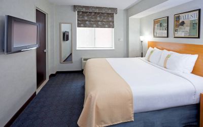 Double bed guest room in the Holiday Inn Express Wall Street, with window, TV, and mirror.