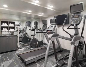 Various exercise machines, towels, and TV in the hotel’s fitness center.