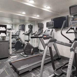 Various exercise machines, towels, and TV in the hotel’s fitness center.