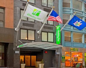 Exterior shot of the Holiday Inn Express Wall Street and its trio of fluttering flags.