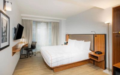 Guest room in La Quinta Times Square South, complete with double bed, large window, TV, and workspace.