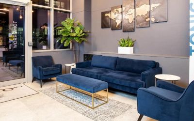 The lounge located in La Quinta Times Square South’s lobby, with comfy seating and potted plants.
