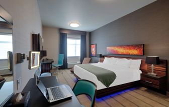 Comfortable king room with work desk and TV at Hotel Clique Calgary Airport.