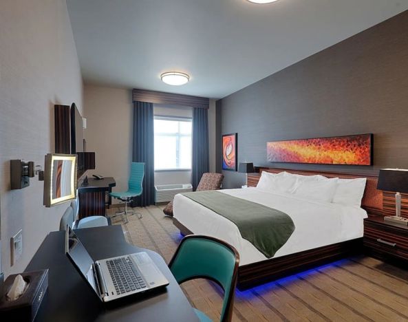 Comfortable king room with work desk and TV at Hotel Clique Calgary Airport.