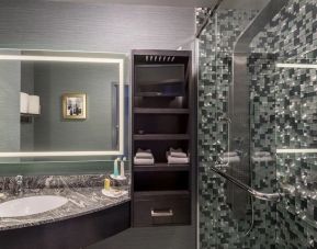 Spacious guest bathroom with shower at Hotel Clique Calgary Airport.