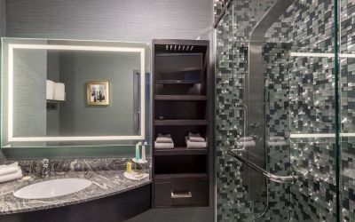 Spacious guest bathroom with shower at Hotel Clique Calgary Airport.