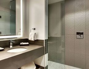 Private guest bathroom with shower at The Rose Hotel Chicago O’Hare, Tapestry Collection By Hilton.