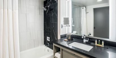 Private guest bathroom with shower and tub at DoubleTree By Hilton Washington DC North/Gaithersburg.